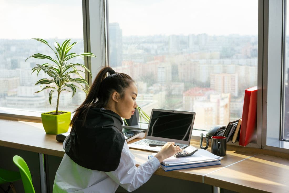 An accountant working at a desk in a high-rise office