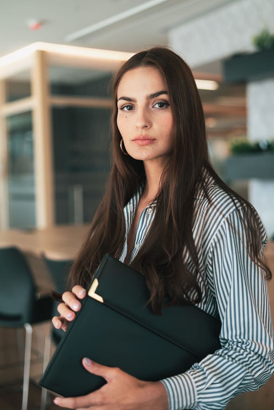 An advisor holding a client folder in a modern office