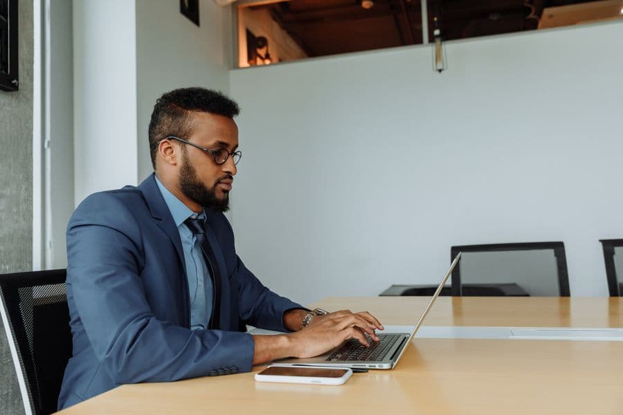 A founder working through filings on a laptop in a meeting room