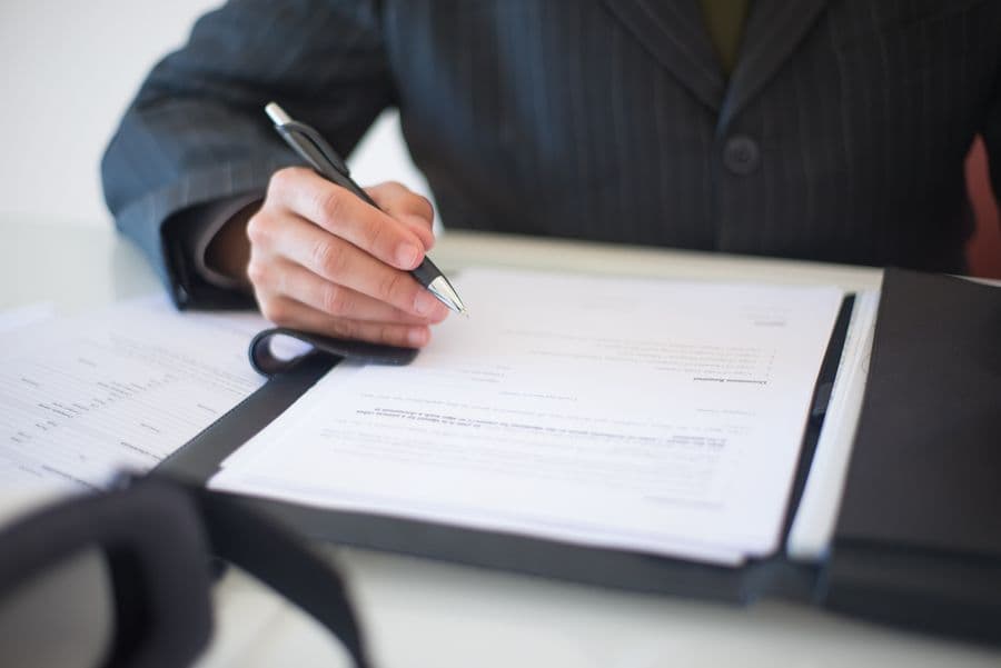 A director signing incorporation paperwork at a desk