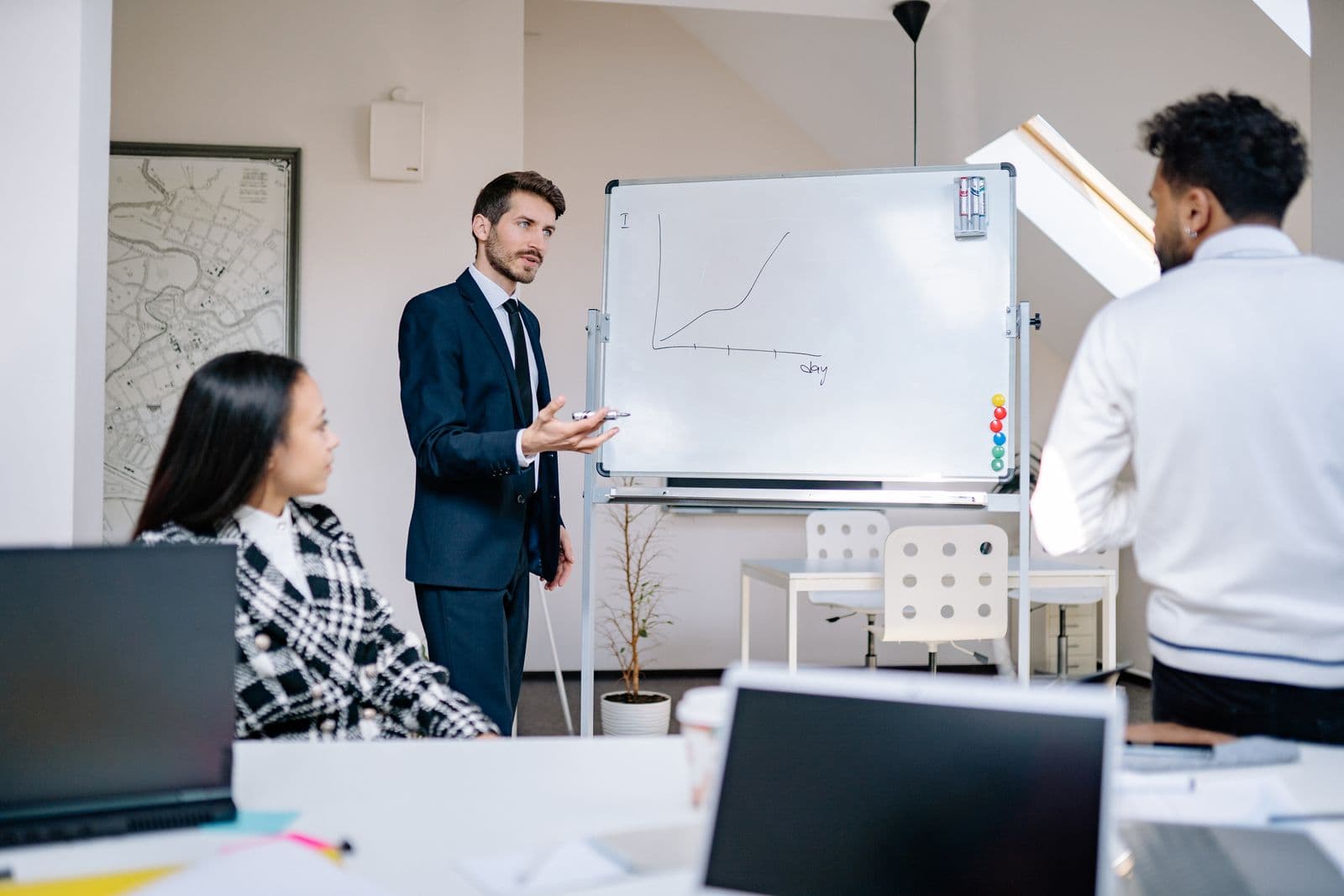 An advisor presenting a growth chart to colleagues in a bright office