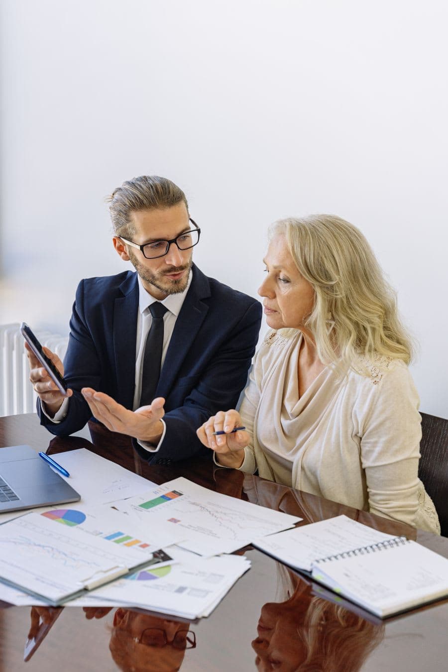 An advisor walking a client through figures at a boardroom table