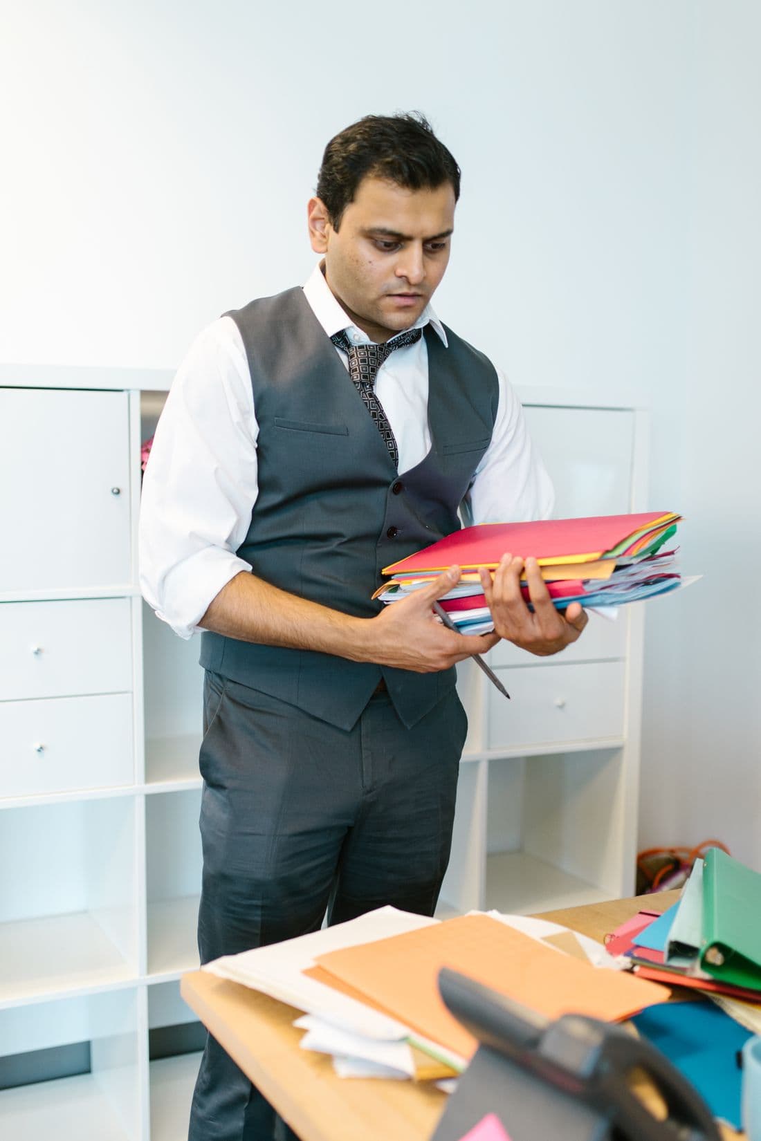 An office manager pulling company files from a shelf