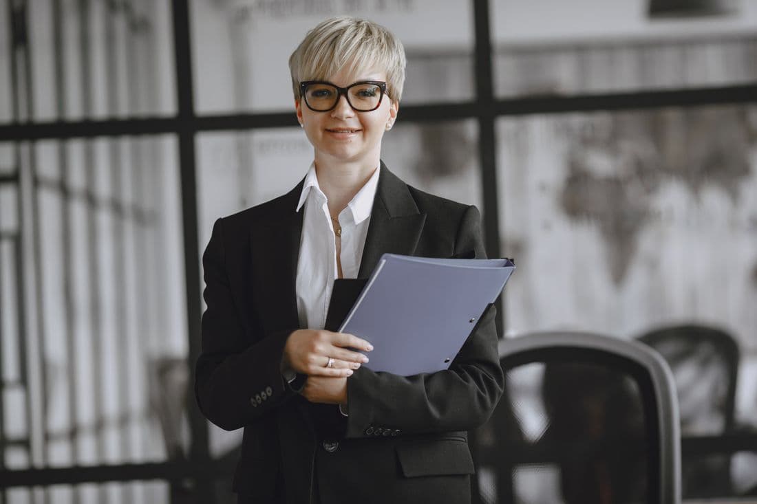 A professional holding a company file in a modern office