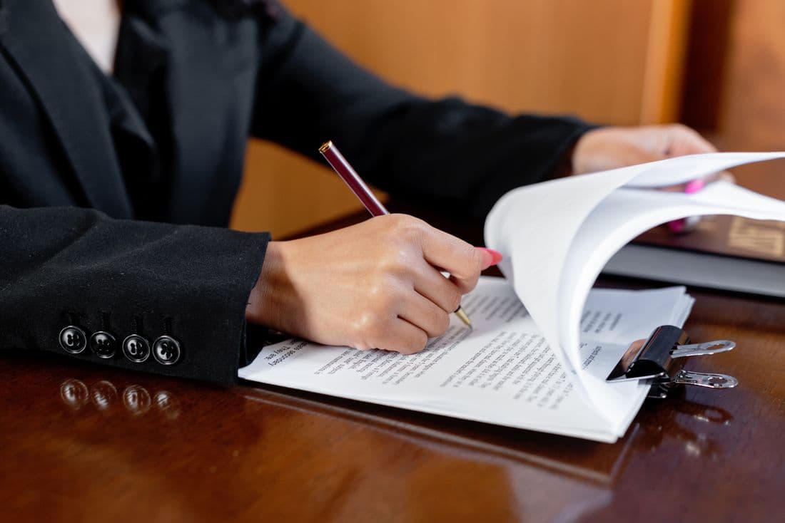 A director signing a statutory filing at a desk
