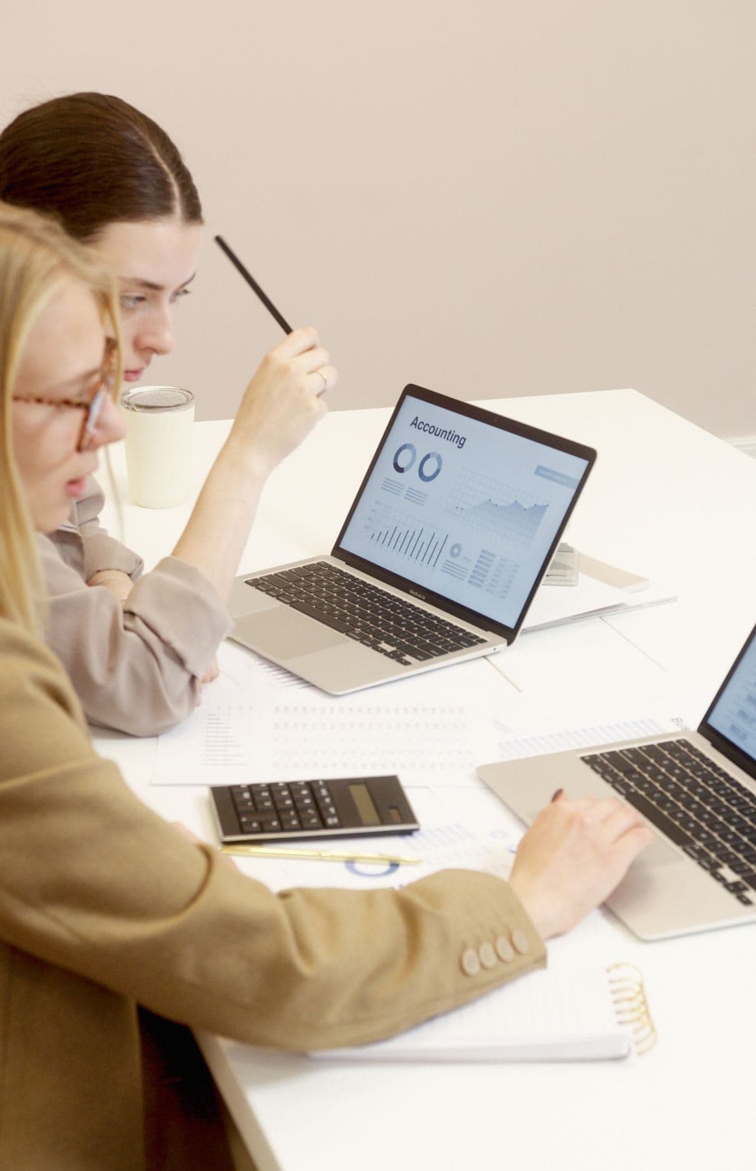 Two colleagues rebuilding a set of accounts together on laptops